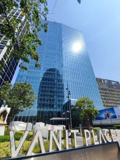 Vanit Place Ari, a blue glass office tower seen from below, with large Vanit Place letters in the foreground