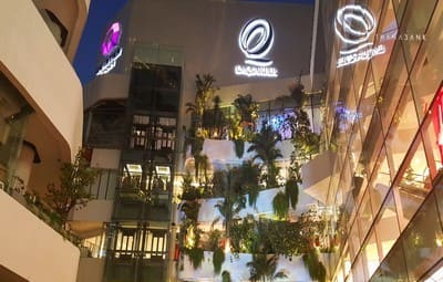 EmQuartier at dusk, looking up a courtyard of stacked planted terraces between glass mall buildings